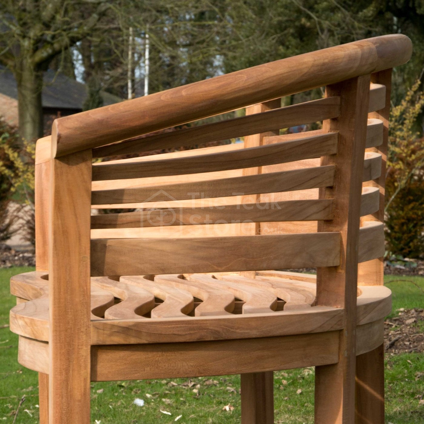 Side profile of the Lewes teak banana bench showing smooth curved armrests.